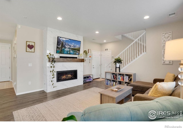 living room featuring dark wood-type flooring and a fireplace