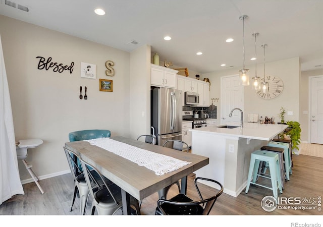 dining area with light hardwood / wood-style flooring and sink