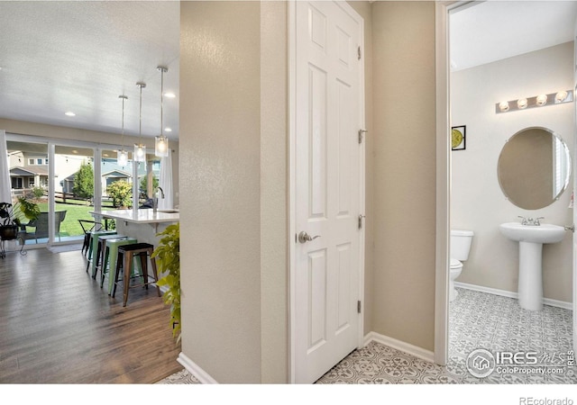 interior space with wood-type flooring, a textured ceiling, and sink