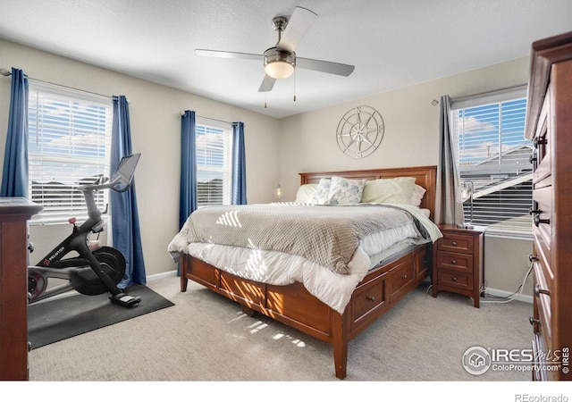 bedroom featuring multiple windows, ceiling fan, and light colored carpet