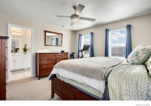 carpeted bedroom featuring ensuite bath, a textured ceiling, and ceiling fan