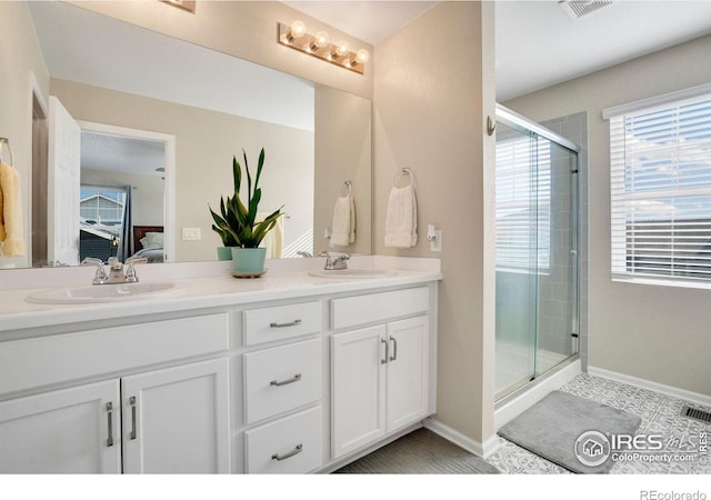 bathroom featuring a shower with shower door, tile patterned flooring, and vanity