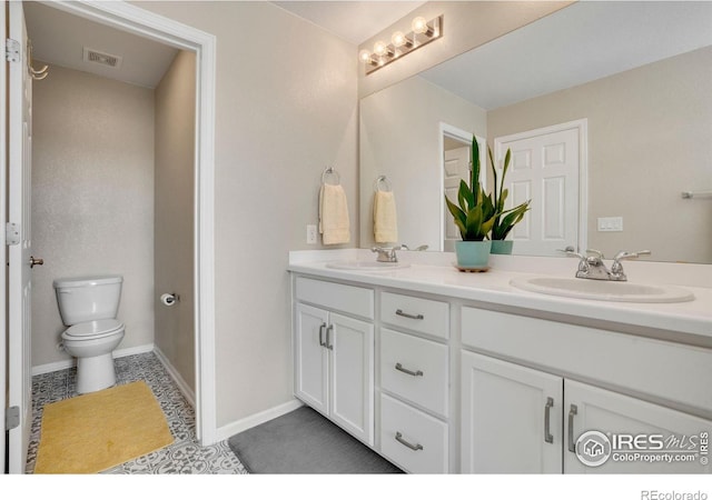 bathroom featuring vanity, toilet, and tile patterned flooring