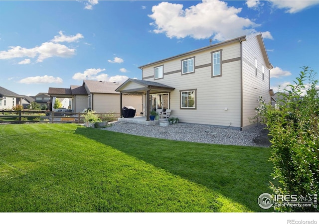 rear view of property featuring a patio area and a lawn