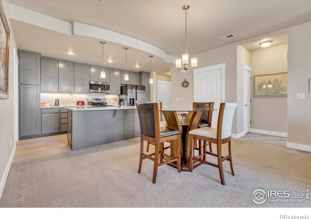 carpeted dining area featuring an inviting chandelier