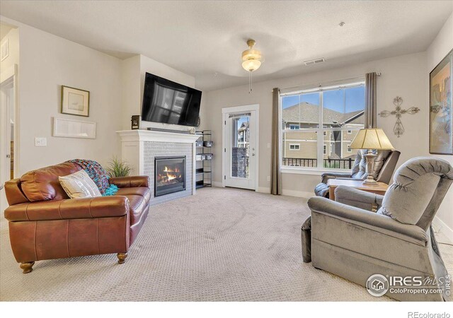 living room with carpet floors, a fireplace, and a healthy amount of sunlight