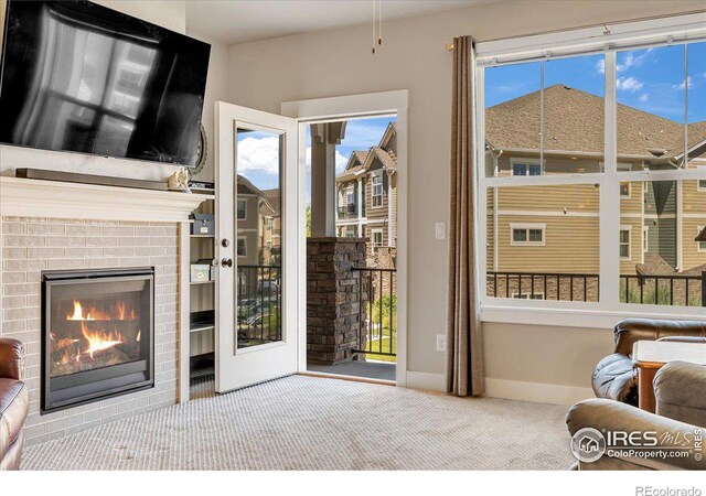 carpeted living room with a fireplace and a healthy amount of sunlight