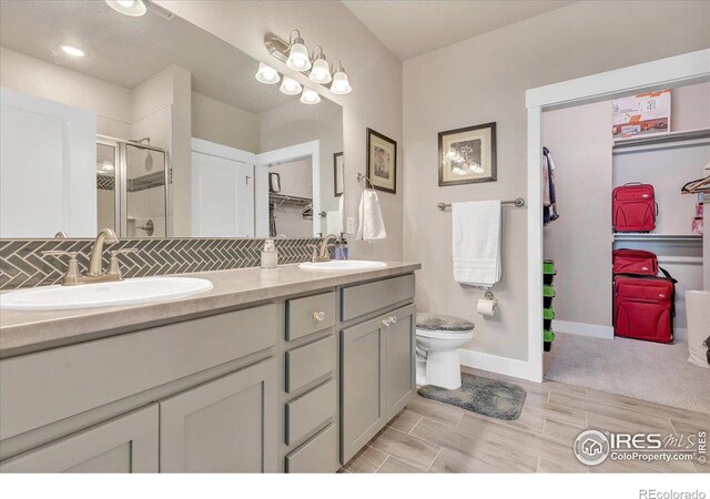 bathroom with vanity, toilet, hardwood / wood-style floors, and an enclosed shower