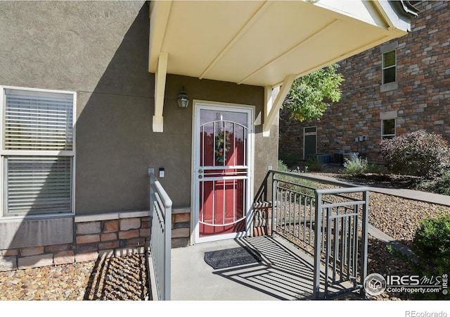 view of exterior entry with brick siding and stucco siding