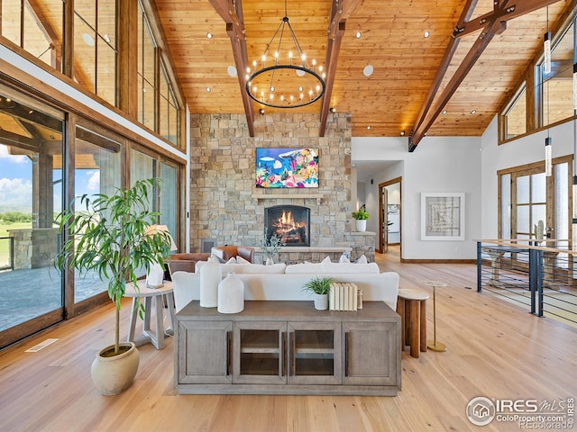 living area with light wood-type flooring, wooden ceiling, high vaulted ceiling, and a stone fireplace