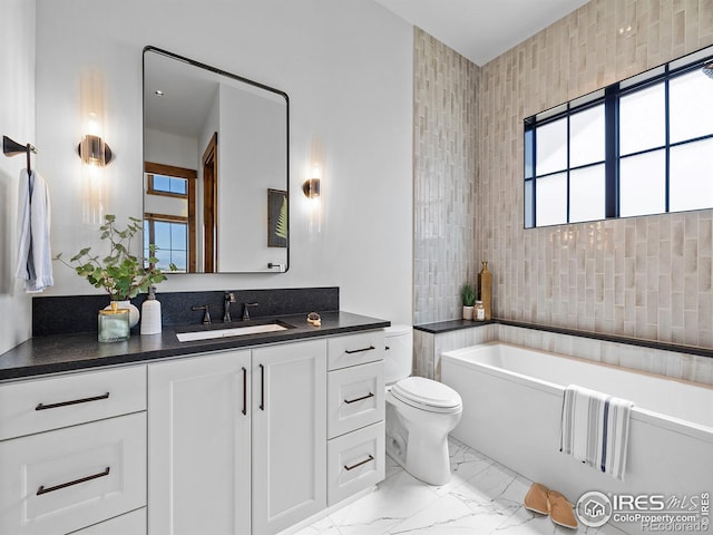 full bathroom featuring marble finish floor, radiator heating unit, toilet, a bathing tub, and vanity