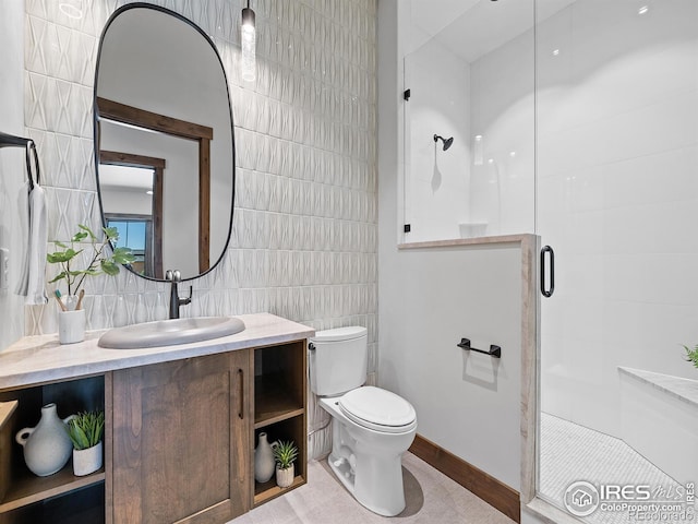 bathroom featuring toilet, a stall shower, vanity, and tile walls