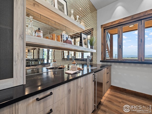 bar featuring tasteful backsplash, baseboards, dark wood finished floors, and refrigerator