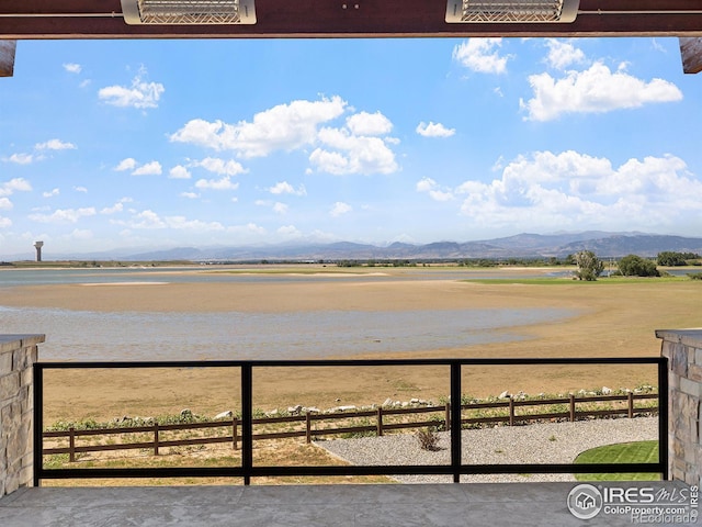 view of water feature featuring fence, a mountain view, and a rural view