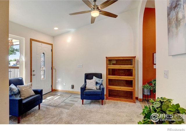 sitting room with ceiling fan and light carpet