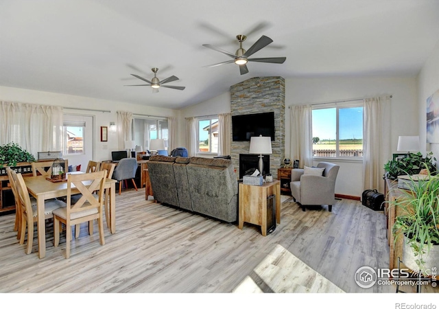 interior space featuring a fireplace, vaulted ceiling, light hardwood / wood-style flooring, and ceiling fan