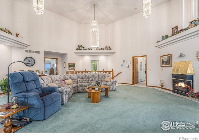 carpeted living room featuring a chandelier and a high ceiling