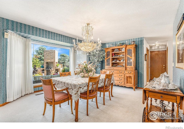 dining space with light carpet, a notable chandelier, and a textured ceiling