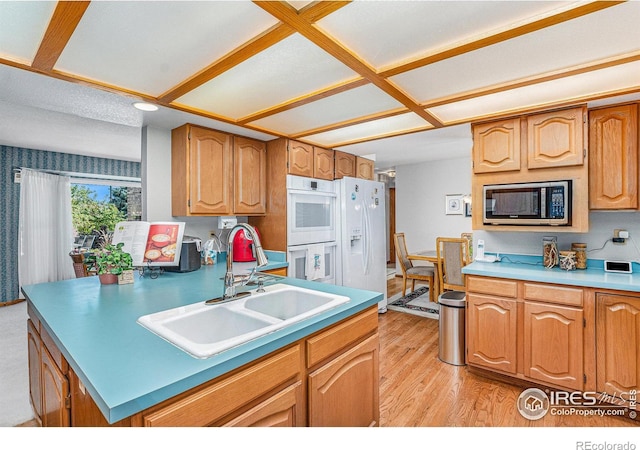 kitchen with light wood-type flooring, coffered ceiling, white appliances, and sink