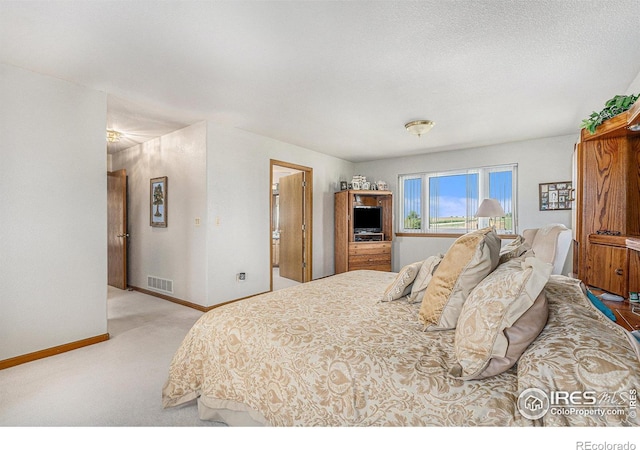 bedroom with a textured ceiling and carpet floors