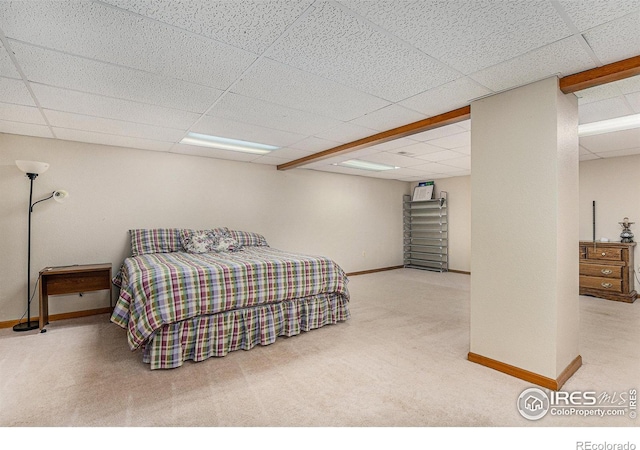 carpeted bedroom featuring a drop ceiling