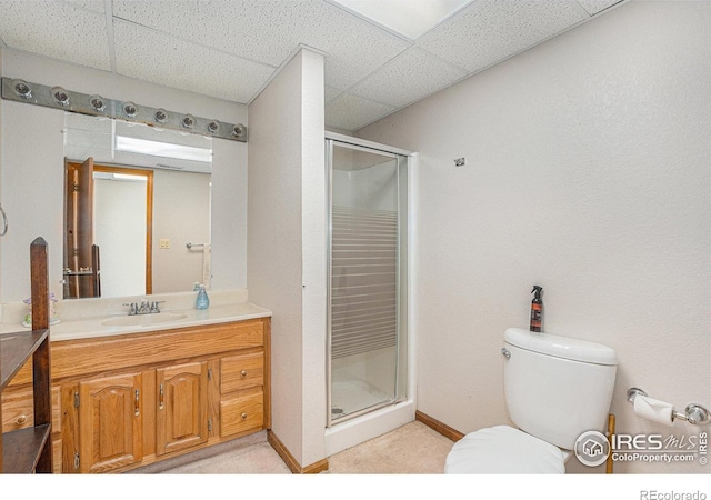 bathroom with vanity, toilet, a paneled ceiling, and a shower with shower door