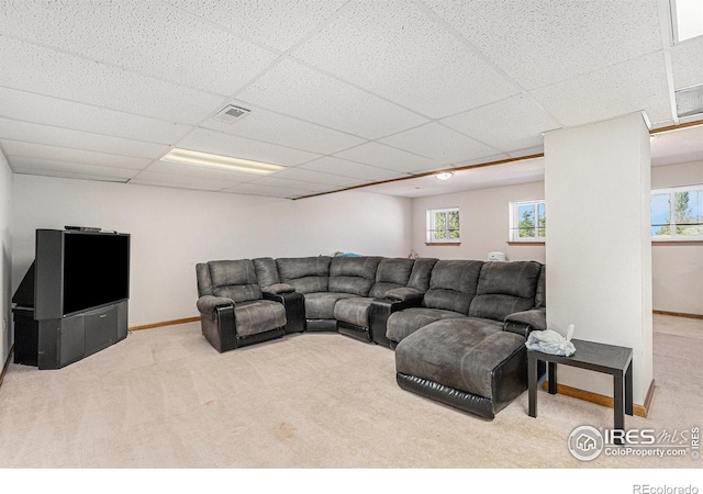 living room with a paneled ceiling and light carpet