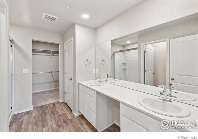 bathroom featuring vanity, hardwood / wood-style flooring, and an enclosed shower