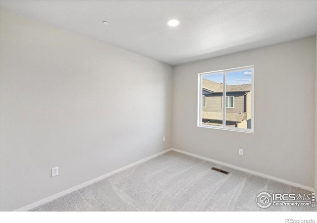 spare room with baseboards, visible vents, and carpet floors