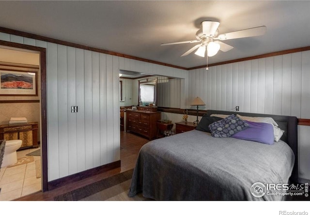 bedroom with ceiling fan, wood walls, and ornamental molding