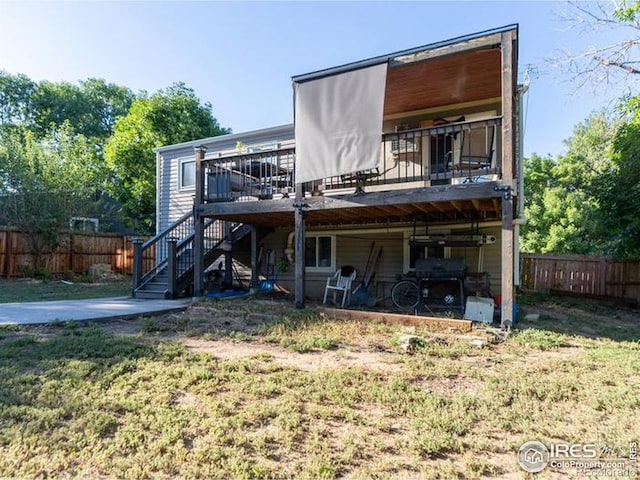 rear view of house featuring stairway, fence, and a wooden deck