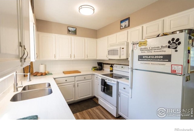 kitchen with tasteful backsplash, white appliances, sink, dark hardwood / wood-style floors, and white cabinets