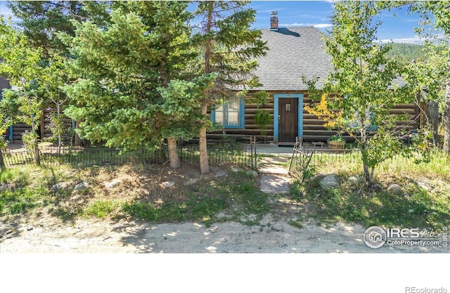 view of front of property featuring a shingled roof and fence