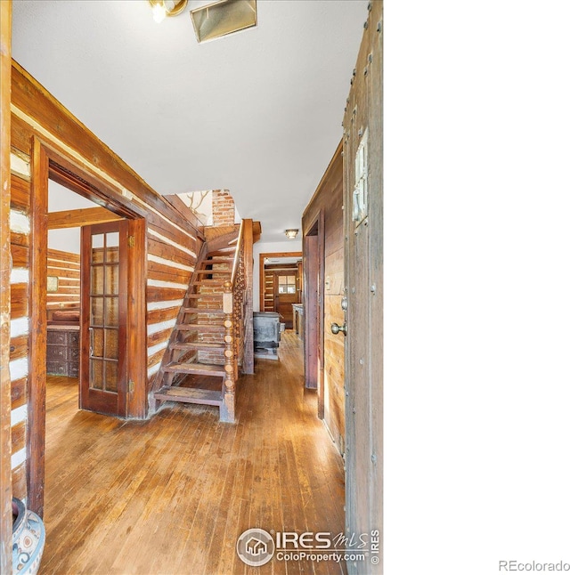 interior space with hardwood / wood-style flooring, stairway, and wooden walls