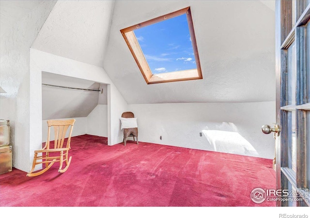 bonus room with lofted ceiling with skylight and carpet