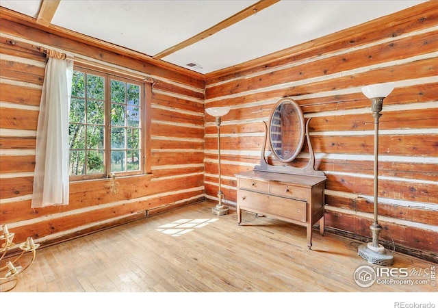 interior space featuring visible vents, wood walls, and hardwood / wood-style floors