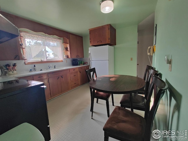 kitchen featuring backsplash, sink, and white fridge