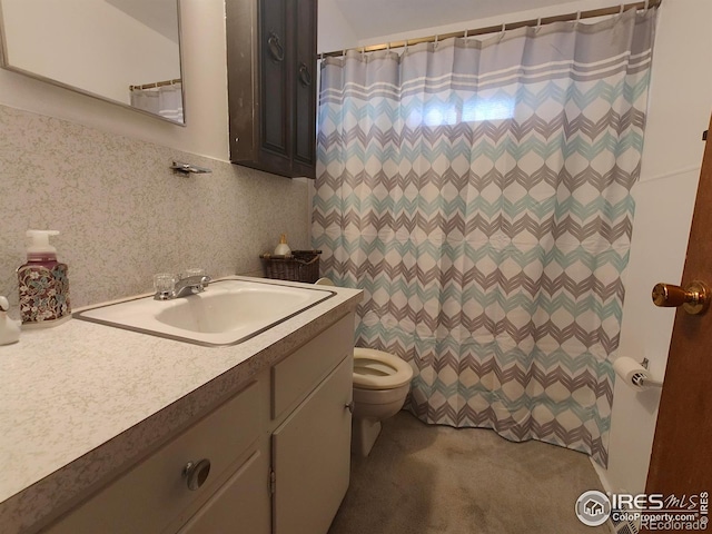 bathroom featuring toilet, tasteful backsplash, and vanity