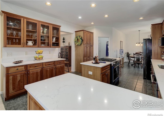 kitchen featuring range with gas stovetop, a kitchen island, freestanding refrigerator, and light countertops