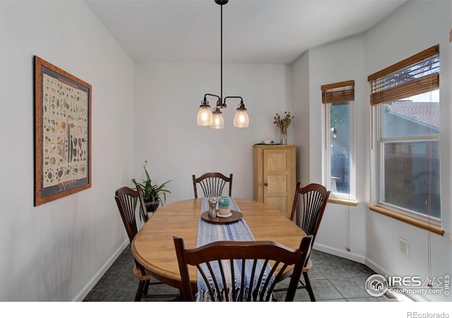 tiled dining area with a wealth of natural light, an inviting chandelier, and baseboards