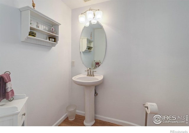 bathroom with wood finished floors and baseboards