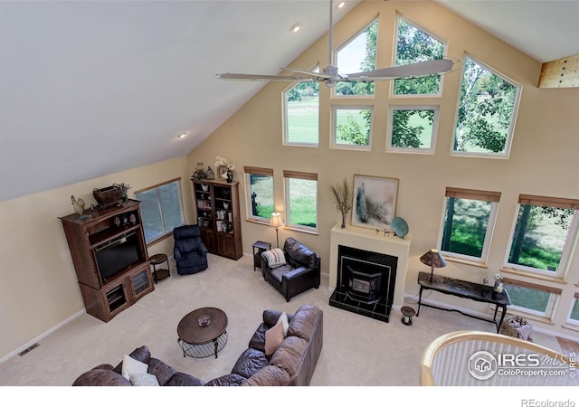 living area with high vaulted ceiling, carpet flooring, visible vents, and plenty of natural light