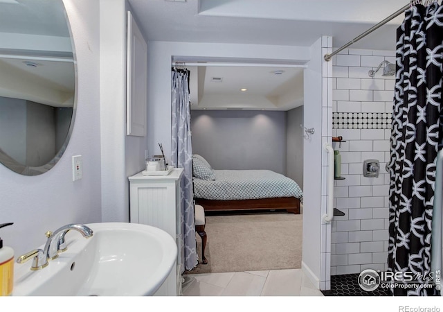 bathroom featuring a tile shower, connected bathroom, tile patterned floors, and a sink