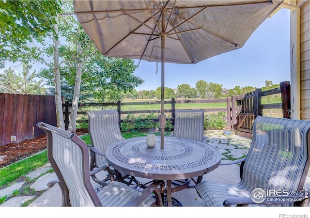 view of patio with outdoor dining space and fence