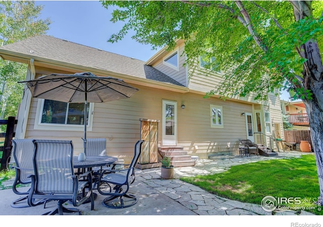 rear view of house featuring a patio area, fence, a shingled roof, and entry steps