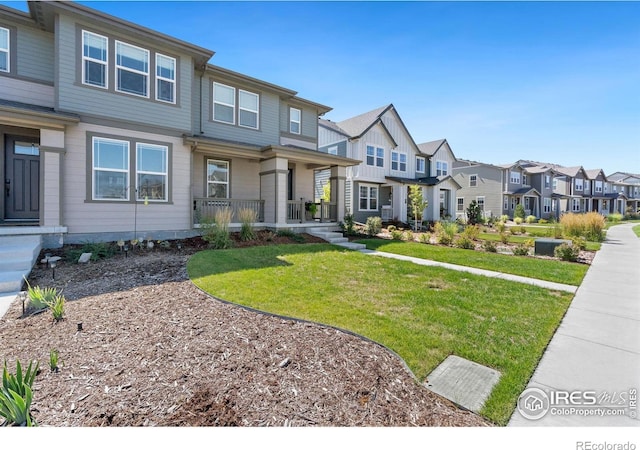 multi unit property featuring covered porch, a residential view, and a front lawn