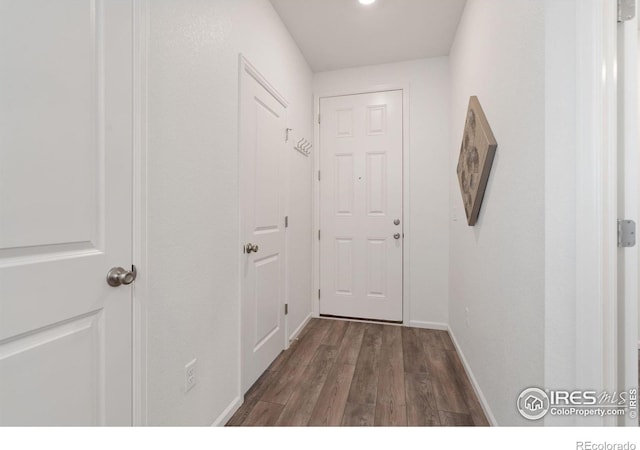 doorway to outside featuring dark wood-style flooring and baseboards