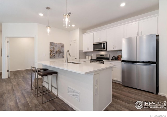 kitchen with tasteful backsplash, visible vents, white cabinets, appliances with stainless steel finishes, and a sink