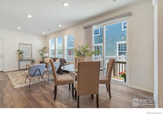 dining space with baseboards, wood finished floors, and recessed lighting