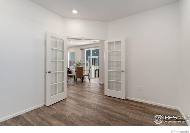 spare room featuring french doors, baseboards, and wood finished floors